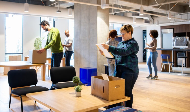 A group of professional workers moving into a new coworking office space, showcasing the seamless office relocation services provided by BRG Office Movers. This image highlights their expertise in managing business relocations, ensuring a smooth transition for teams and companies as they settle into new coworking environments, with efficient and reliable moving solutions nationwide